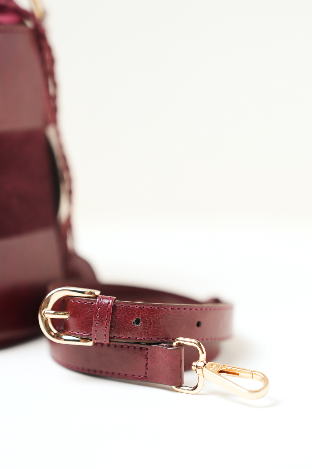 Derby Bucket Bag Burgundy shown with its adjustable shoulder strap.