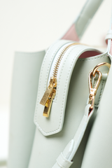 Equitana Top Handle Mint purse displayed with its curved handle and minimal design.