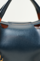 Equitana Top Handle Navy bag photographed to highlight its deep colour and sleek construction.