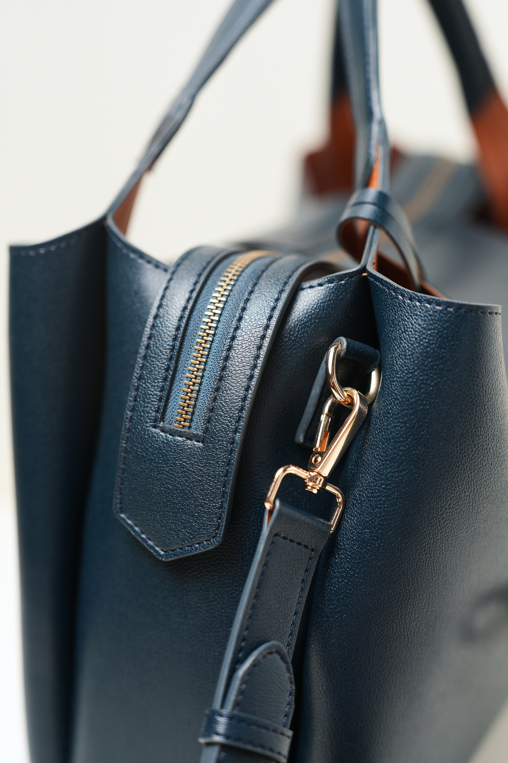 Equitana Top Handle Navy purse displaying its curved handle and minimal, elegant design.