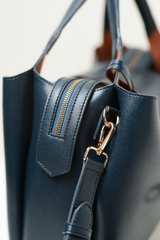 Equitana Top Handle Navy purse displaying its curved handle and minimal, elegant design.