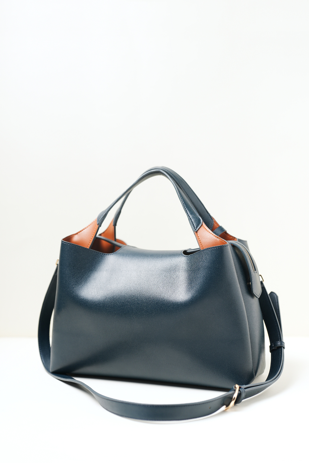 Side profile of the Equitana Top Handle Navy handbag showing its shape and detailing.