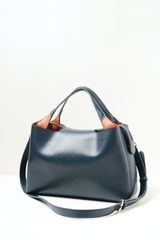 Side profile of the Equitana Top Handle Navy handbag showing its shape and detailing.