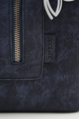 Close-up of the Rodeo Totepack Blue showing the Amrée logo, fine stitching, and premium textured finish.