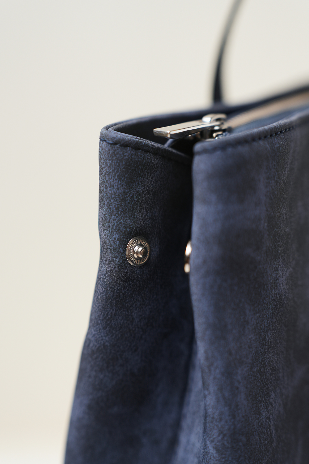 Side close-up of the Rodeo Totepack Blue showing stitching details, side panel structure, and the refined Amrée craftsmanship.