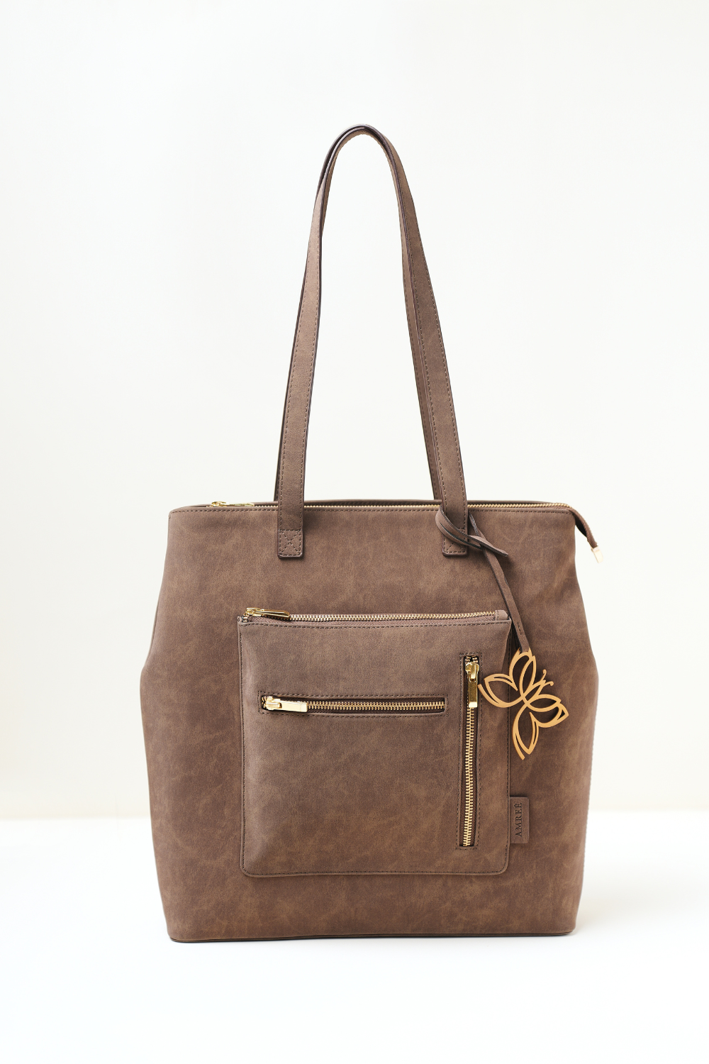 Brown leather tote bag with a gold zipper and butterfly emblem on a white background