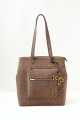 Brown leather tote bag with a gold zipper and butterfly emblem on a white background