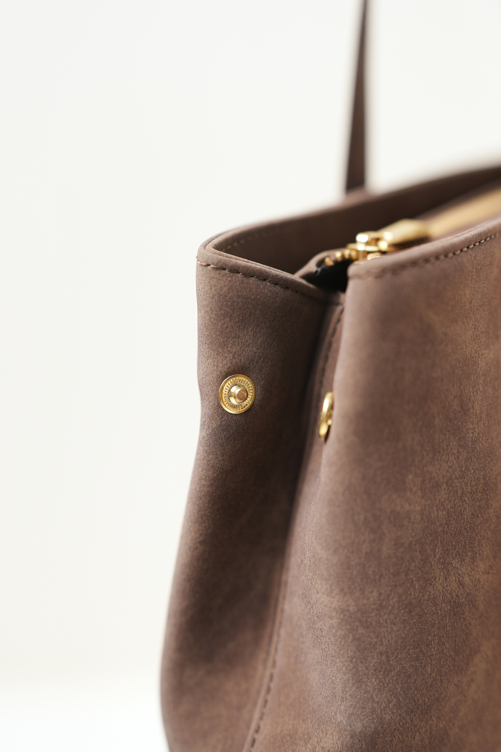 Close-up side view of the Rodeo Totepack Brown showing the button detail, side panel structure, and Amrée’s craftsmanship.