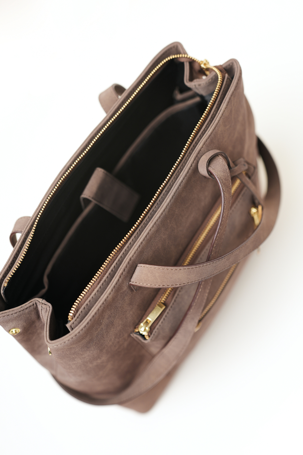 Sideways top view of the Rodeo Totepack Brown with the bag open, showing inner compartments and Amrée’s organised interior layout.