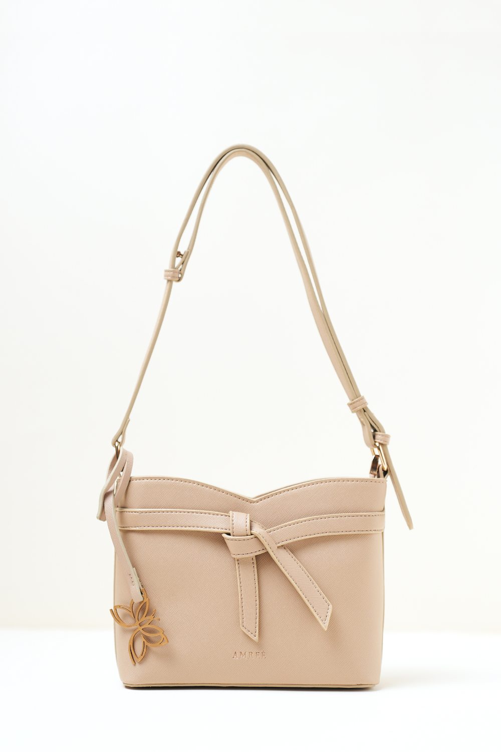 Rosette Sling Beige shown in full front view highlighting its compact silhouette and soft beige tone.