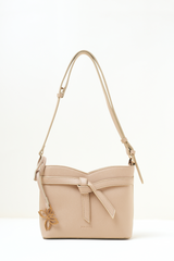 Rosette Sling Beige shown in full front view highlighting its compact silhouette and soft beige tone.
