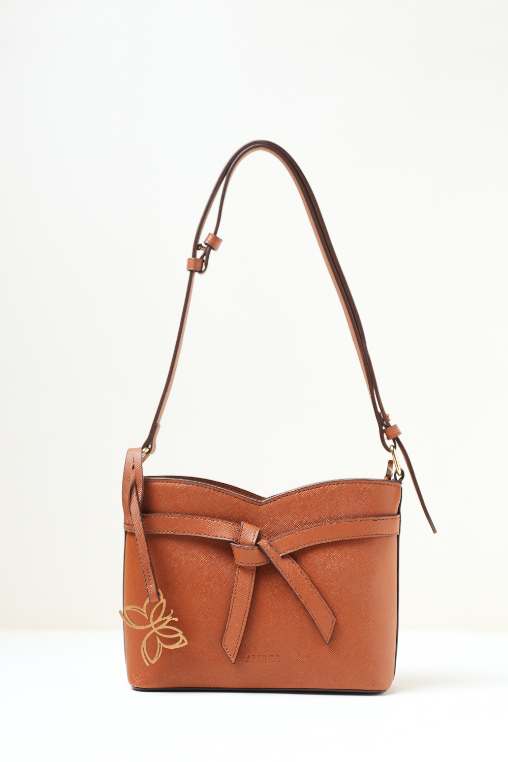 Rosette Sling Tan shown in a full front view highlighting its compact silhouette and warm tan finish.