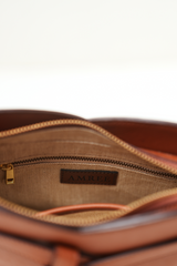 Inside view of the Rosette Sling Tan showing the inner pocket with zipper chain and the Amrée brand tag, highlighting organised interior detailing.