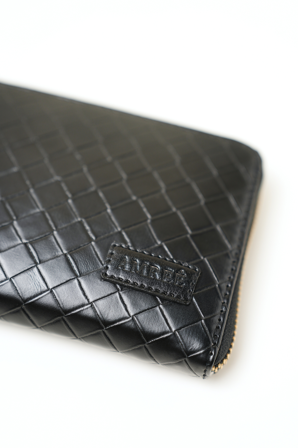 Close-up of The Filly Wallet showing the logo tag with clean stitching and premium textured detailing